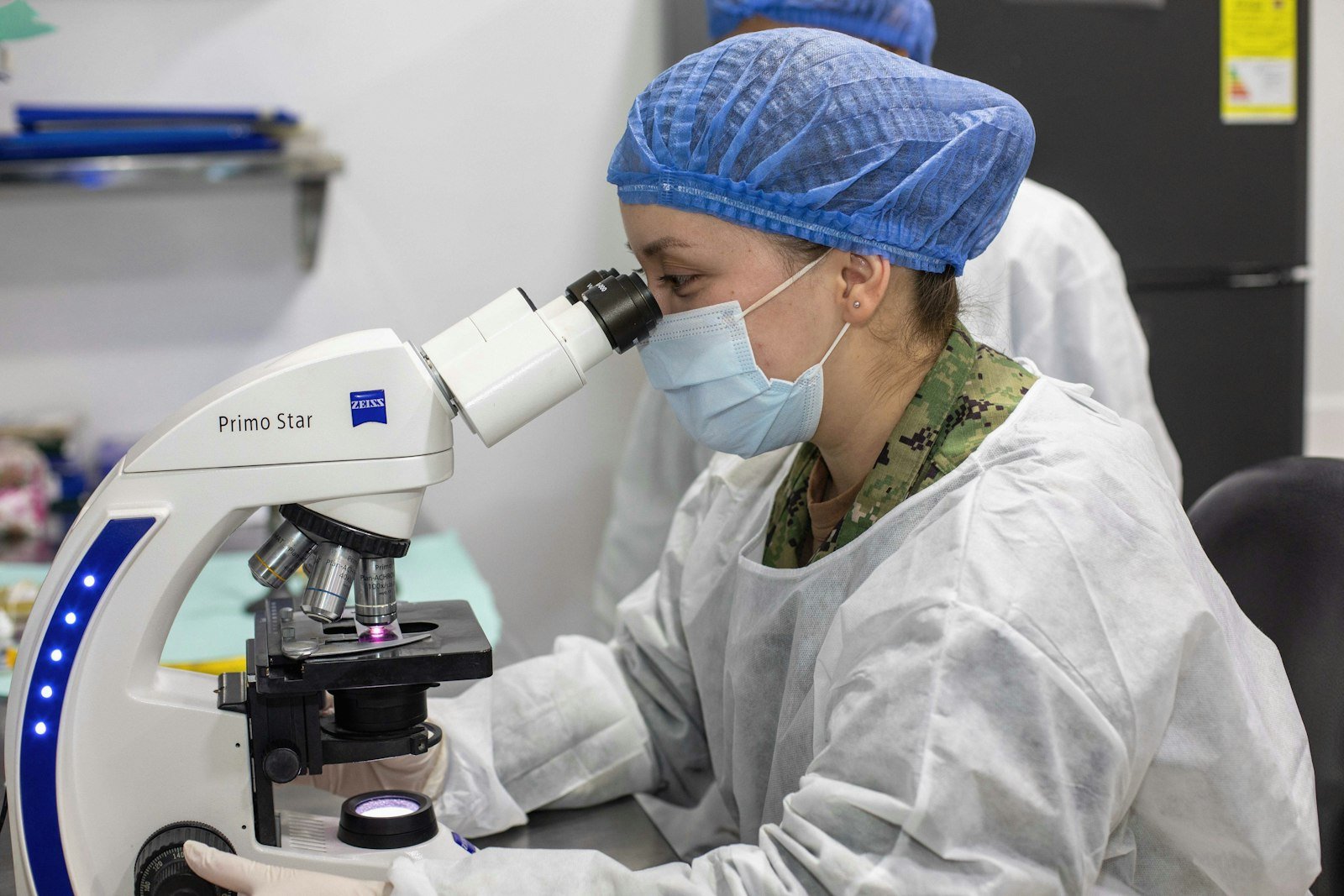 Científico trabajando con un microscopio, referencia a las capacidades de biología de Mythos 5.1